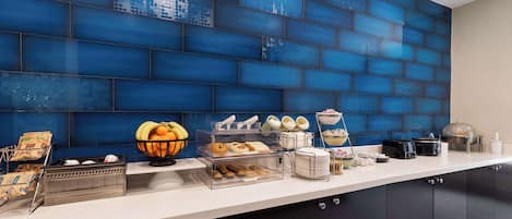 Una barra de desayuno con diversos alimentos y un revoque de azulejos azules.