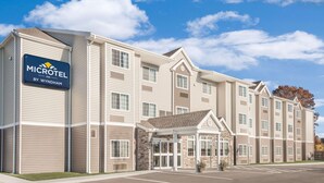 A Microtel Inn by Wyndham hotel with a central entrance, multiple floors, and a parking lot. - Microtel Inn & Suites By Wyndham Binghamton (Binghamton)