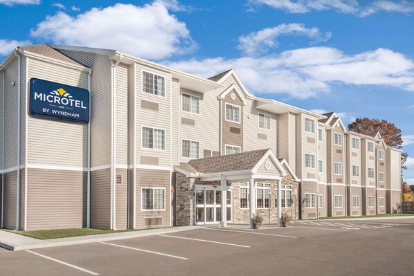 A Microtel Inn by Wyndham hotel with a central entrance, multiple floors, and a parking lot. - Microtel Inn & Suites By Wyndham Binghamton (Binghamton)