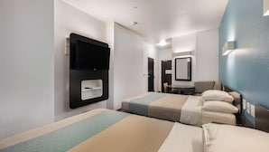 A hotel room with two beds, a desk, a chair, a TV mounted on the wall, and a mirror. - Motel 6 Poplar Bluff, MO (Poplar Bluff)