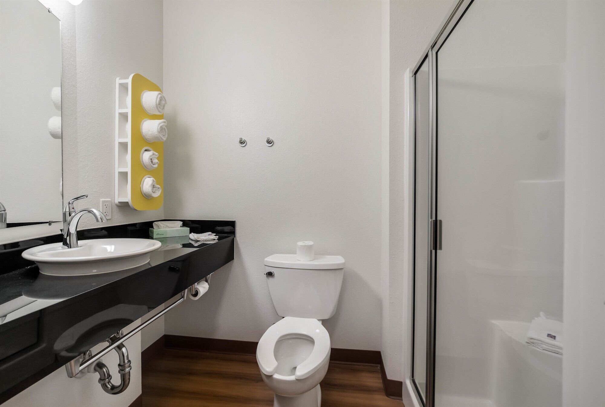 A modern bathroom with a sink, toilet, and shower.