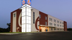 A motel with a prominent '66' sign, large windows, and a flat roof. - Motel 6 Poplar Bluff, MO (Poplar Bluff)