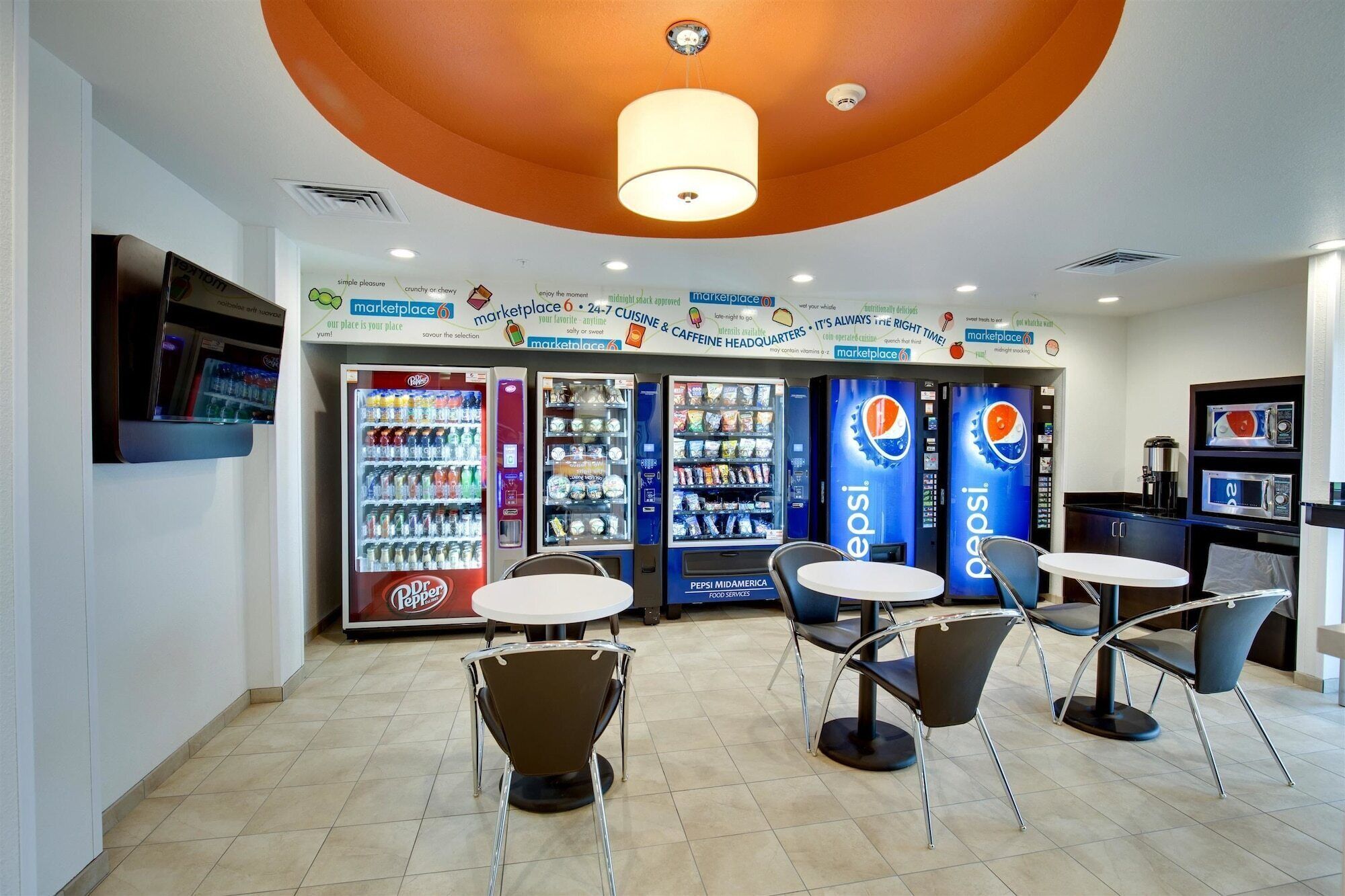 Een foodcourt met automaten, zitplaatsen en een magnetron.