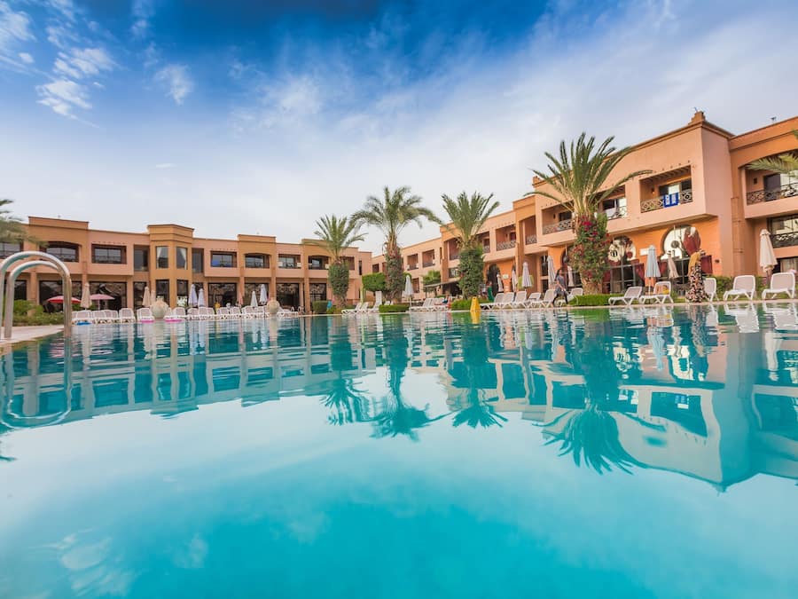 Una piscina al aire libre, sombrillas, tumbonas