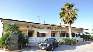 En bygning der hedder "Elizabeth's House" med et skilt, der viser faciliteter som restaurant, bar og fitnesscenter.