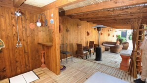 Et interiør i træ med trægulv, en sofa, stole, et bord og en lampe.