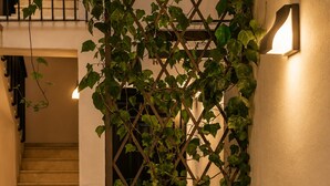 A staircase with a wall-mounted light fixture and a climbing plant. - Casa Lavanda by Blossom Hotels (Granada)