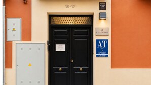 A black double door with a warning sign, a utility box, and a sign reading 'CASA LAWANDA' on a beige wall. - Casa Lavanda by Blossom Hotels (Granada)