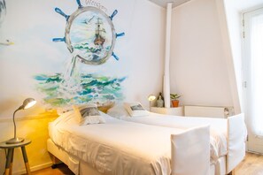 Habitación con 2 camas individuales | Caja fuerte, cunas (de pago), wifi gratis y ropa de cama
