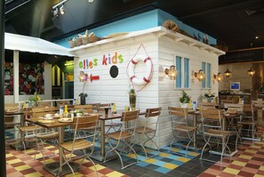 A children's restaurant with a colorful checkered floor, wooden tables, and chairs. - Hotel Pannenkoekhuis Vierwegen (Domburg)