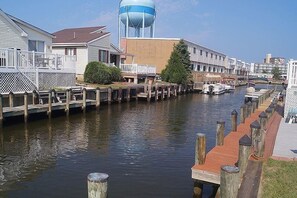 A canal with wooden walkways and boats, surrounded by residential buildings and a water tower.
