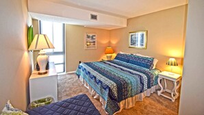 A bedroom with a bed, two bedside tables, a window, and a door. - Braemar 503N 2 Br condo by RedAwning (Ocean City)