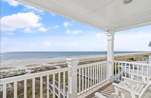 A covered porch with a view of the beach and ocean. - 1 Ez Access 4 Bedroom Home by RedAwning (Supply)