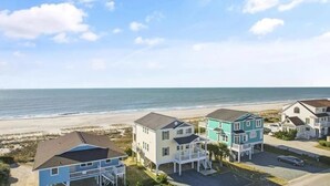 Una propiedad frente a la playa con varias casas, una playa y cielo despejado.