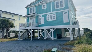 A two-story house with a balcony and a covered porch.
