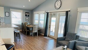 A spacious living area with a dining table, a sofa, and a coffee table. - 3/4 Time - 4 Br Home (Supply)