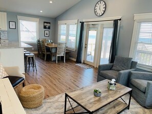 A spacious living area with a dining table, a sofa, and a coffee table.
