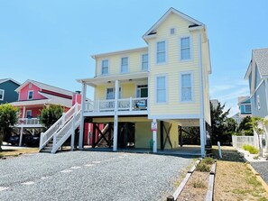 A multi-story building with a covered entrance and a staircase leading to the upper floor.