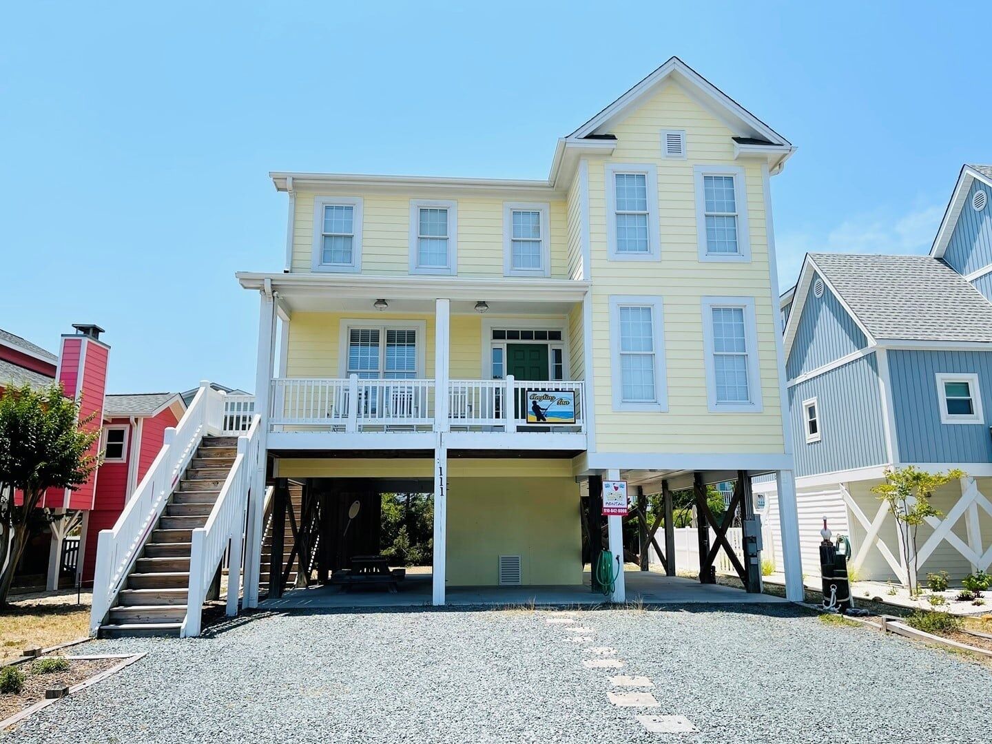 A two-story building with a covered front porch and a staircase leading to the entrance.