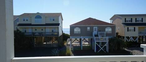 A beachfront hotel with multiple buildings, a covered walkway, and a view of the ocean.