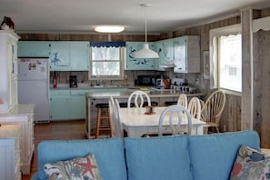 A compact kitchen with wooden cabinets, a dining table, and chairs.