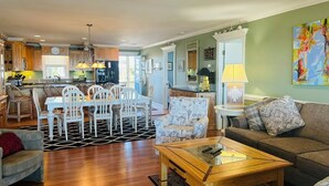 A spacious living area with a dining table, chairs, a sofa, and a coffee table.
