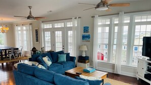 Una sala de estar con un sofá azul, una mesa de centro de madera y un mueble para televisión.