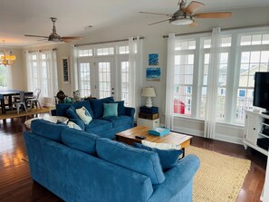 Una sala de estar con un sofá azul, una mesa de centro de madera y un mueble para televisión.
