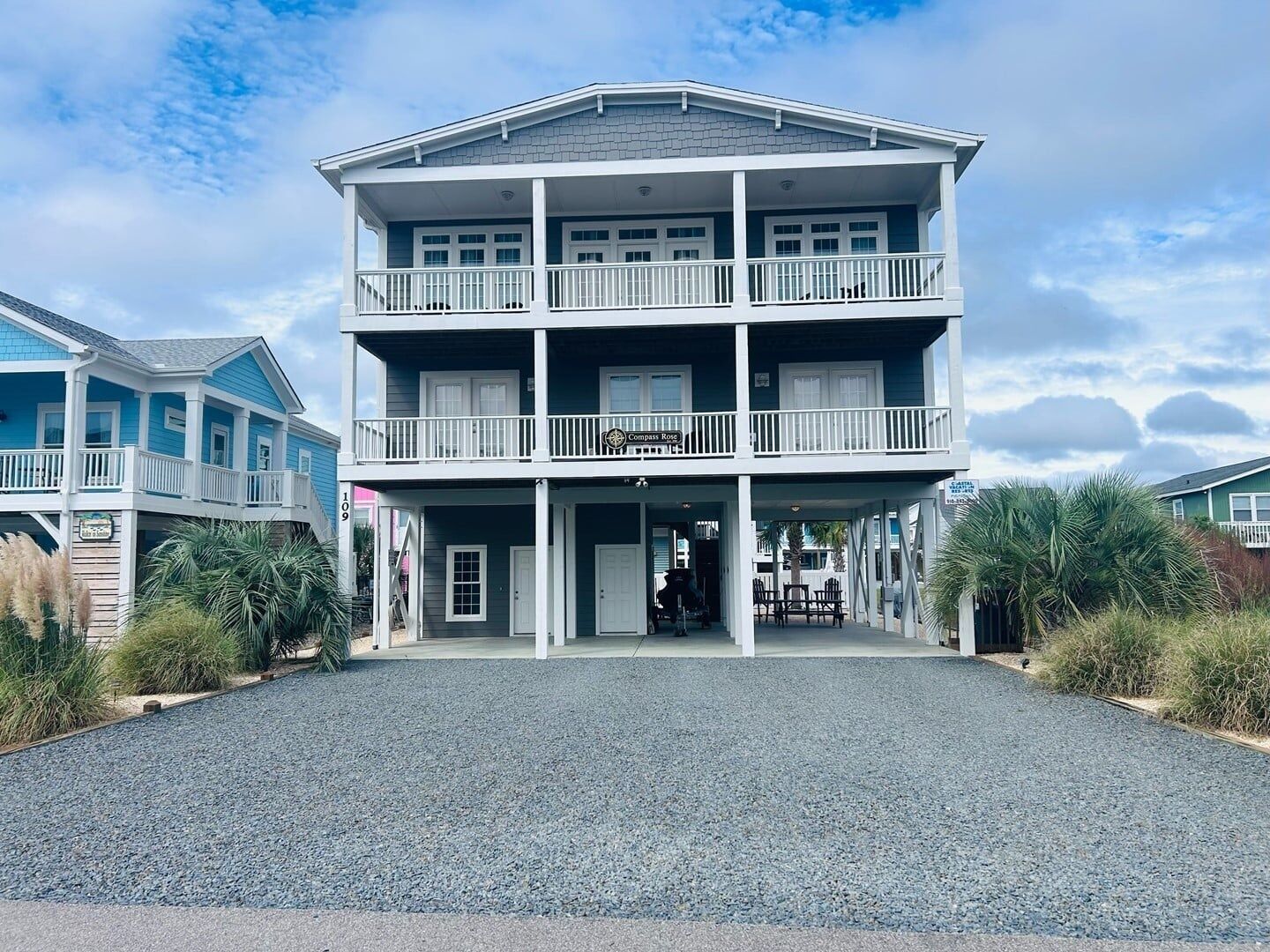 A two-story building with a covered front porch and a sign that reads 'Compass Rose.'