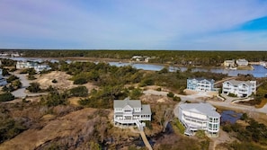 Uma área residencial costeira com várias casas grandes, um cais e um lago.