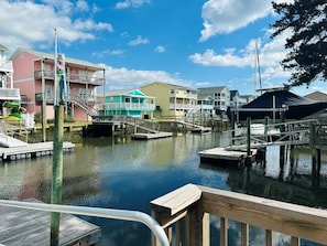 A waterfront property with a dock, a pier, and a small bridge connecting to a building with a balcony.