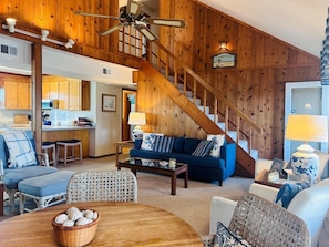 A wooden interior with a staircase, a sofa, a dining table, and a kitchen area. - Dry Dock - 4 Br Home (Supply)