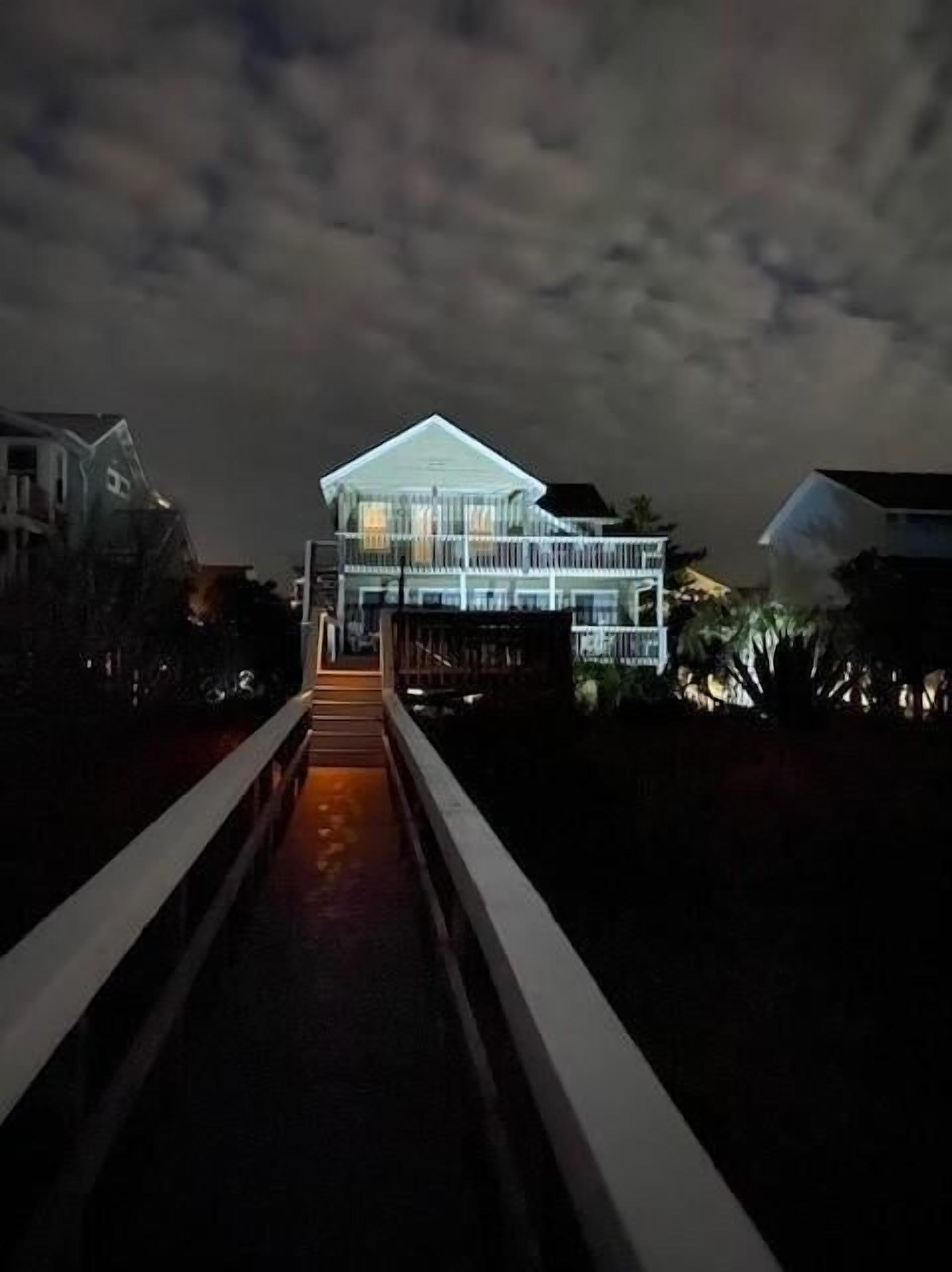A modern building with a prominent entrance and a pathway leading to it.