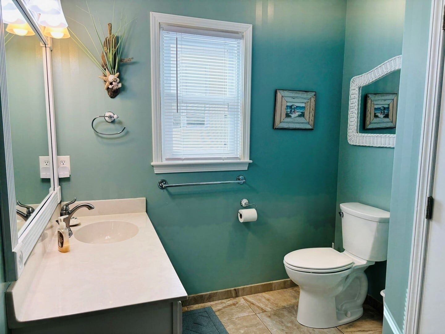 Une salle de bain équipée d’un lavabo, de toilettes, d’une fenêtre et d’un porte-serviettes.