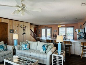 Ein Wohnzimmer mit einer Couch, einem Couchtisch und einem Essbereich mit Stühlen und einem Tisch.