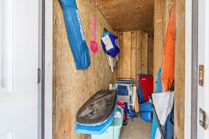 Een kleine houten kamer met een bankje, een blauwe tas en een rode tas die aan de muur hangt.