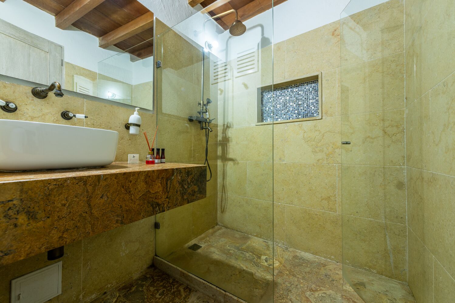Un baño con un lavamanos grande, una ducha y un espejo.