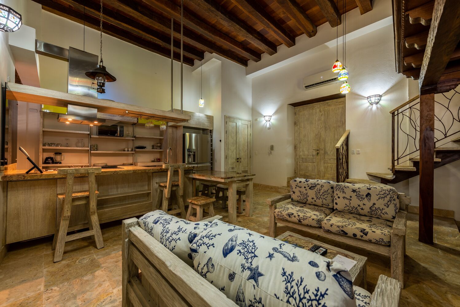 Una cocina rústica con muebles de madera, una mesa de comedor y un sofá con estampado.