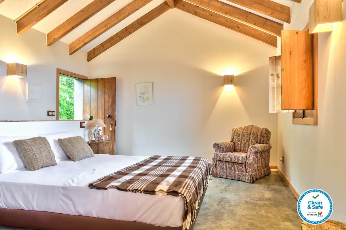 Une chambre à coucher avec un lit, une chaise et une fenêtre.