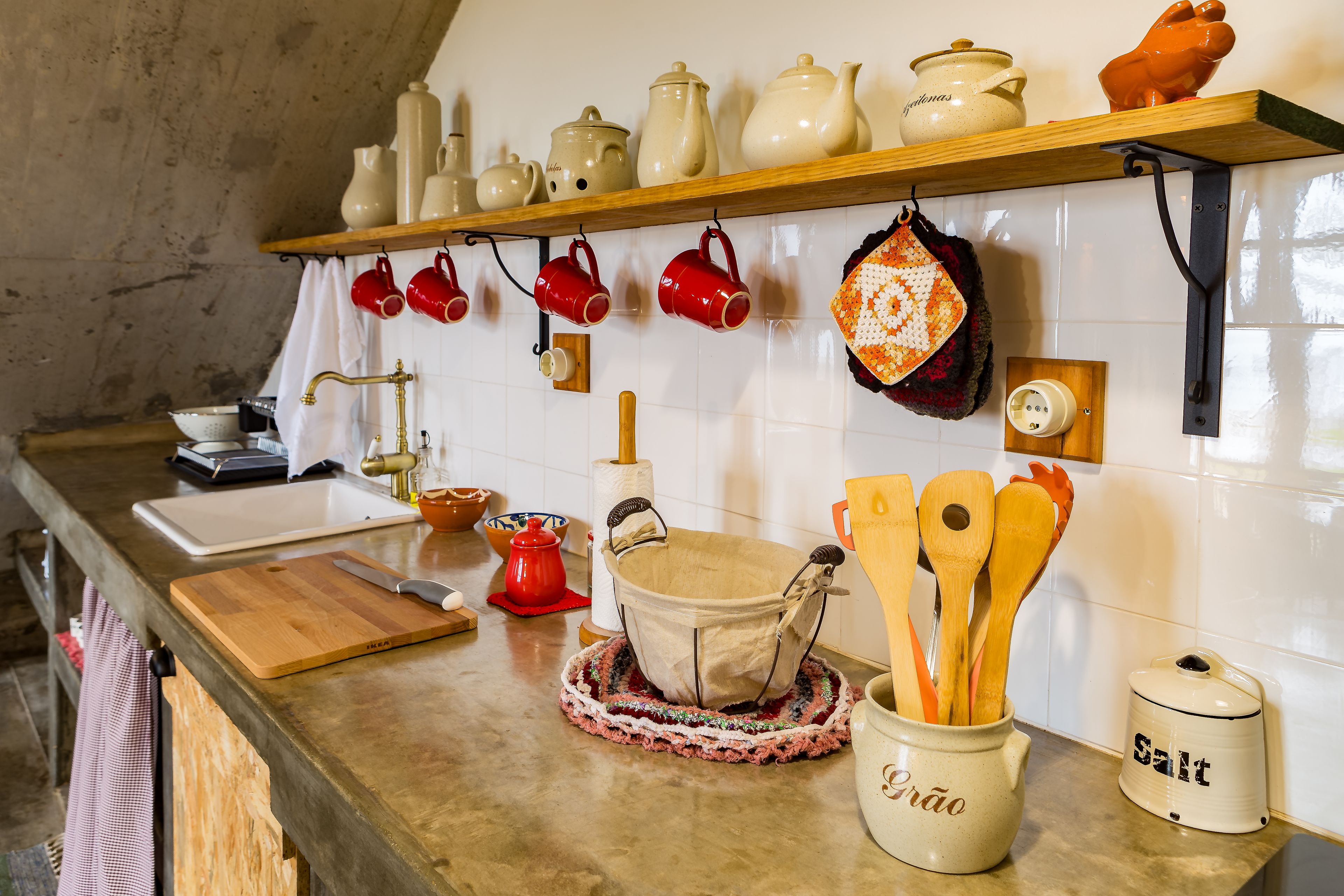 Una cocina con encimera de madera, un fregadero y diversos utensilios y electrodomésticos.