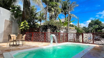 Una piscina al aire libre, sillones reclinables de piscina