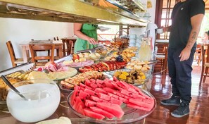 Un bufé con una variedad de alimentos, incluyendo frutas, carnes y postres.