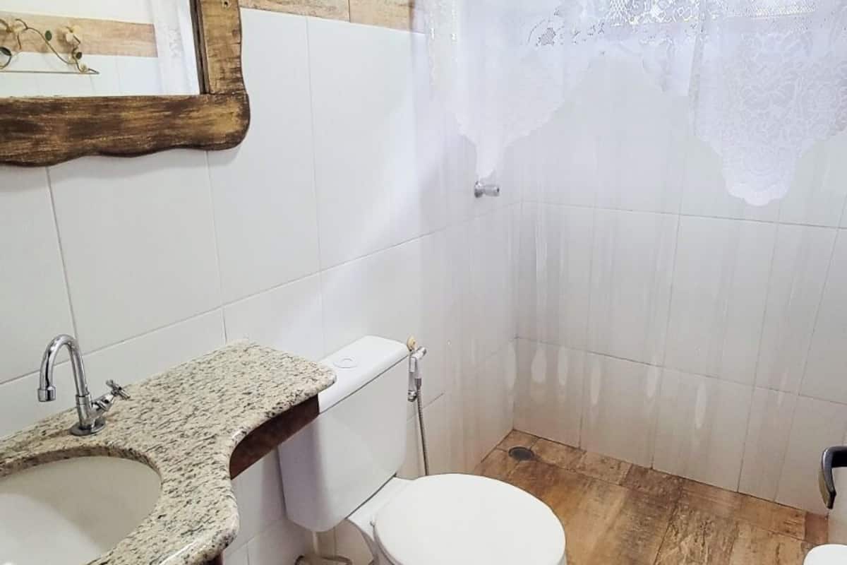 Un baño con lavamanos de granito, inodoro y cortina de ducha.