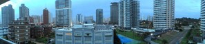Un quartier urbain dense, avec de grands immeubles modernes, un terrain de sport et un mélange de bâtiments résidentiels et commerciaux.