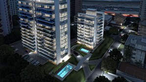 Un moderno edificio de gran altura con varios balcones, una piscina en la azotea y vistas al océano.