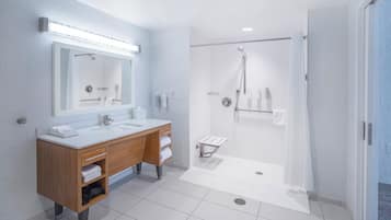 Een moderne badkamer met een grote spiegel, twee wasbakken, een douche en een handdoekrek.