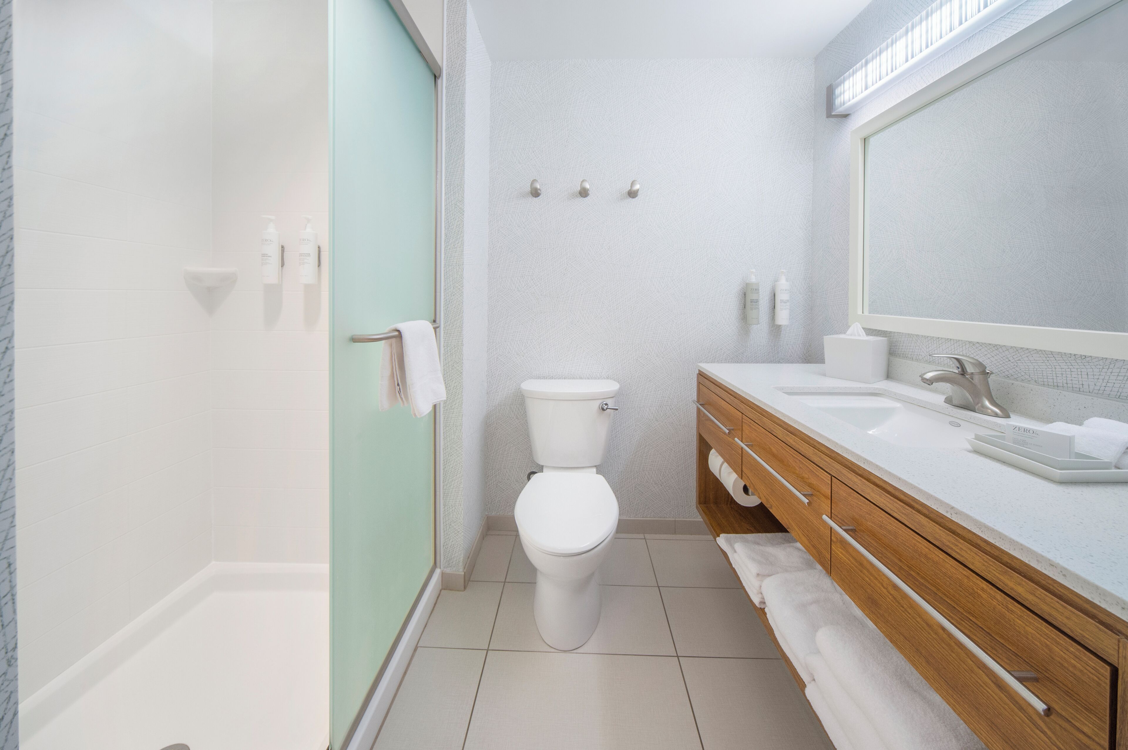 A modern bathroom with a toilet, sink, and shower.