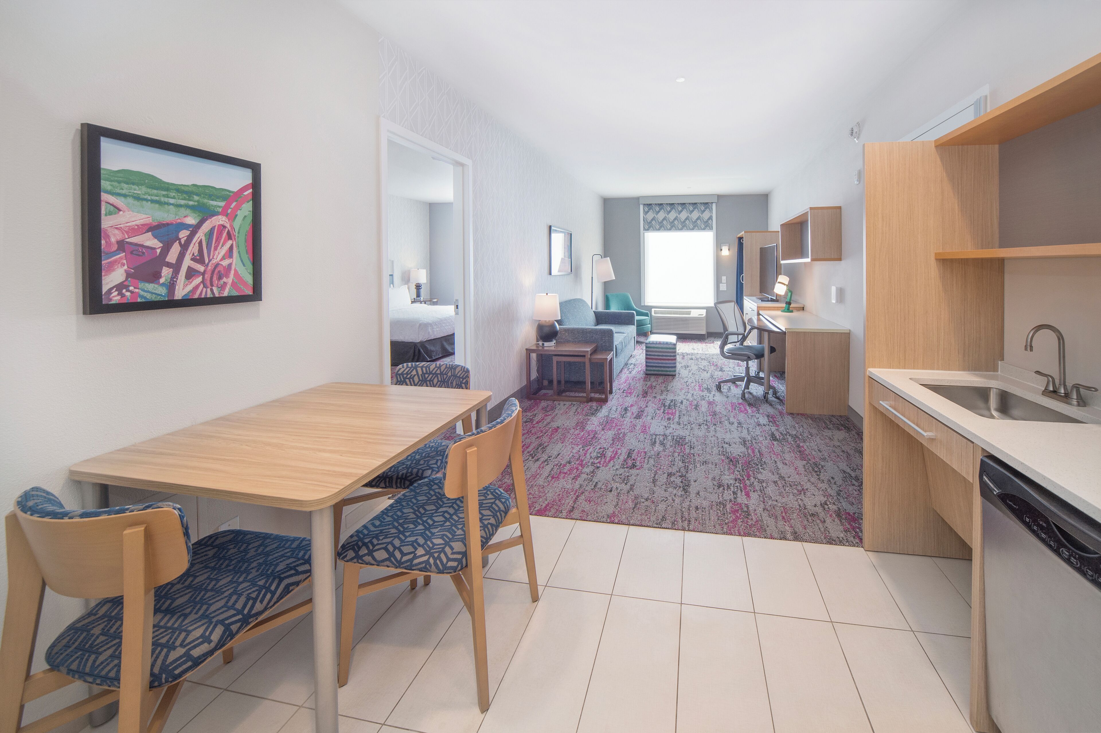 Una habitación de hotel moderna con comedor, cocina y sala de estar.