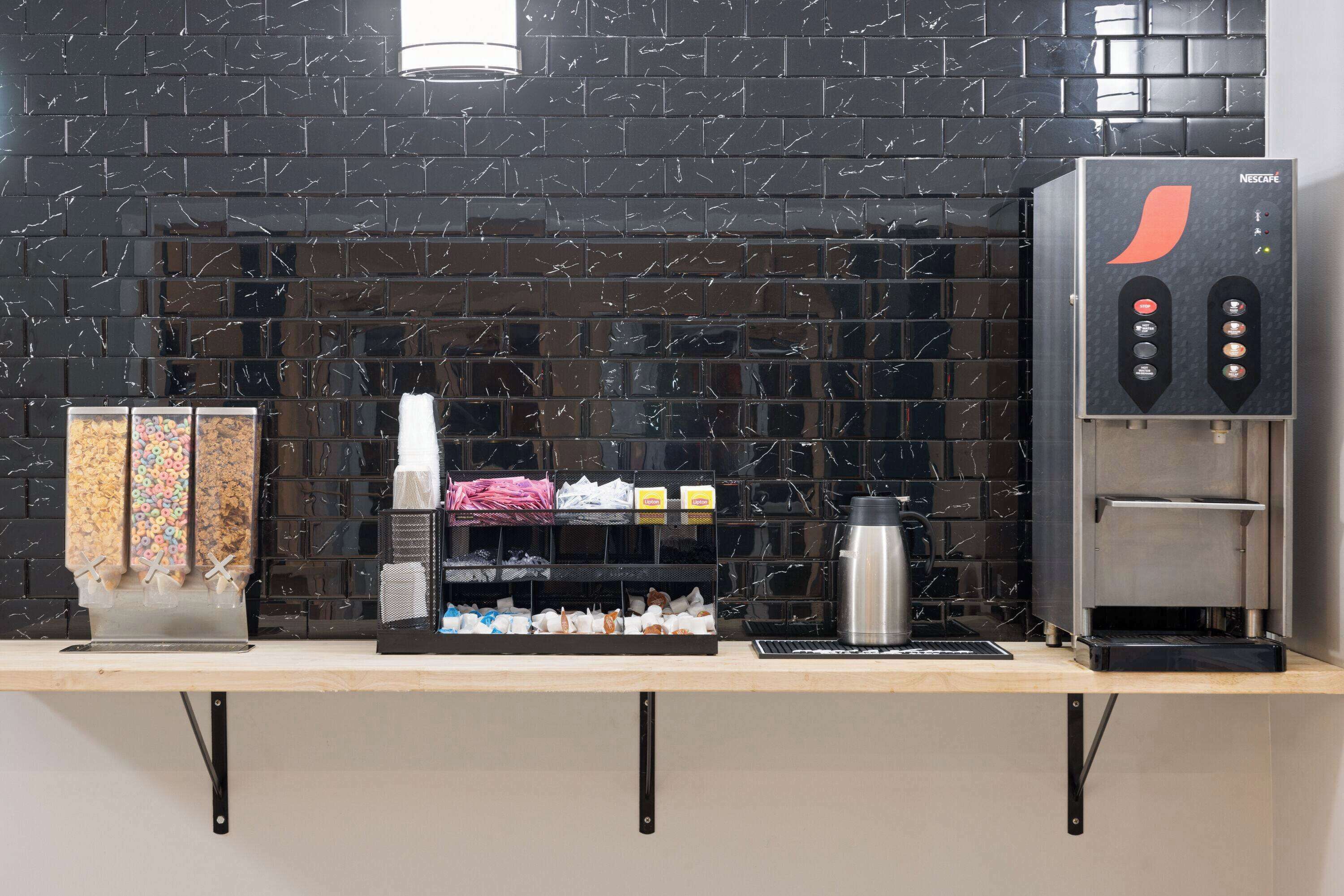 Un espace dédié au café, équipé d'un distributeur de Nescafé, d'un mousseur à lait et d'un distributeur de sucre.