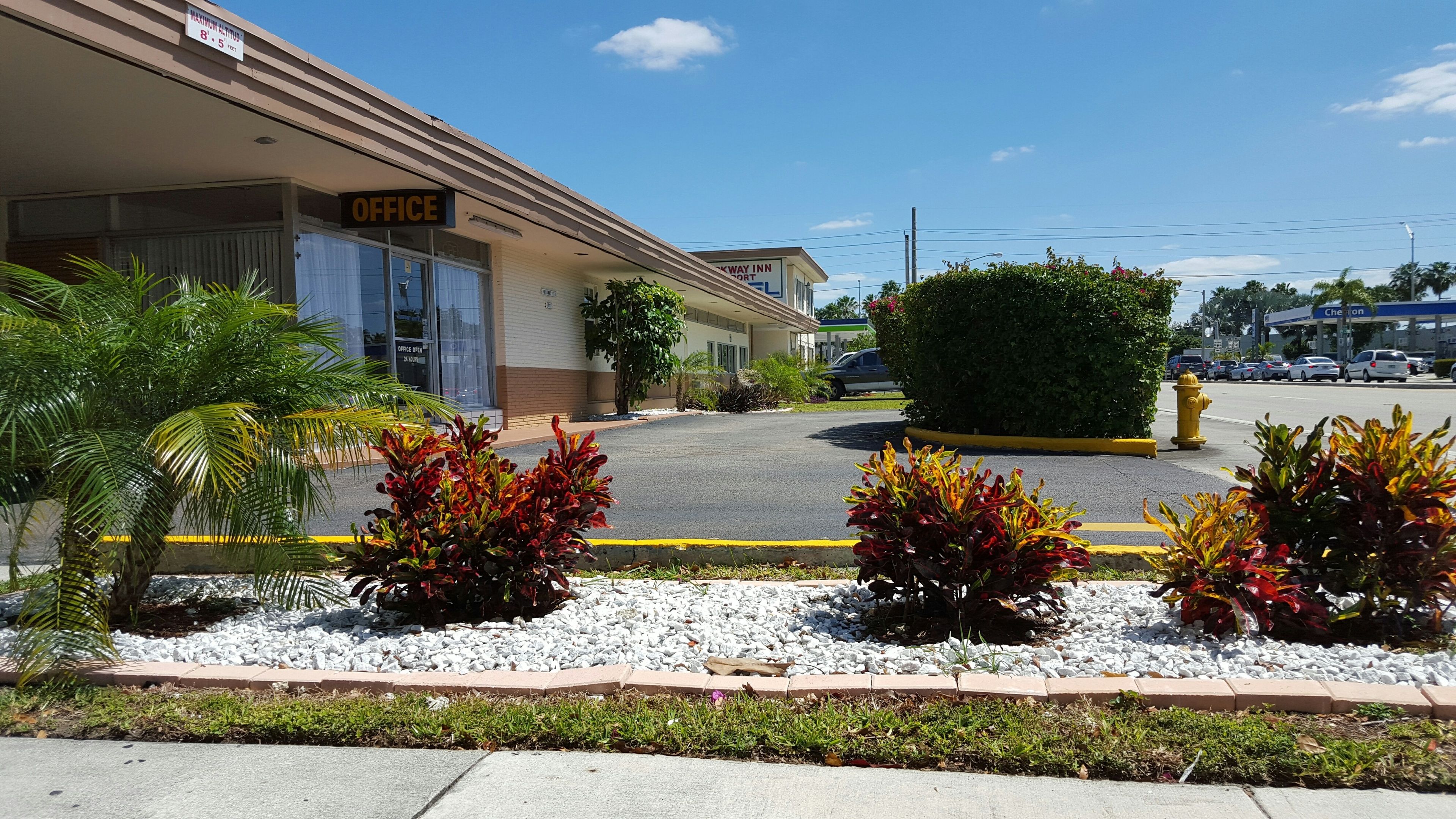 A building with an 'OFFICE' sign, a parking lot, and a 'KEYWAY INN' sign in the background.